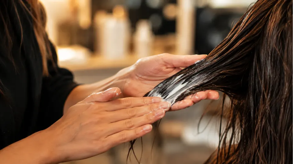 Application d'un soin densifiant sur cheveux clairsemés en salon